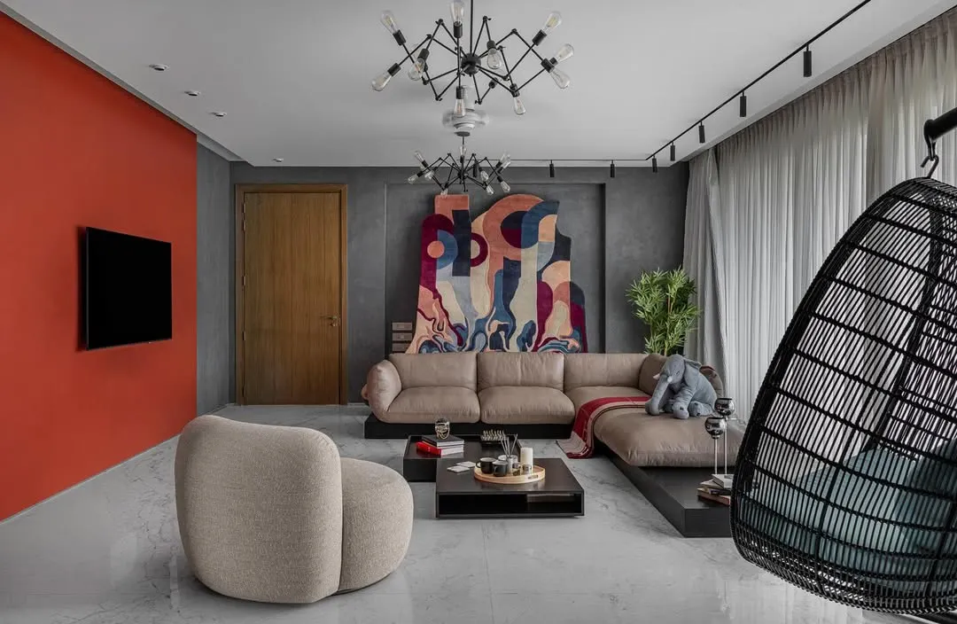 This living space in Upper Juhu, Mumbai, is a study in contrasts, designed for a young, sophisticated couple. We balanced the industrial feel of raw concrete with a bold, colourful accent wall and curated abstract art, creating an environment that is both refined and full of personality. The design seamlessly integrates areas for relaxation and social engagement.