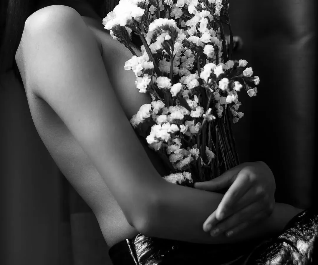 An example of my artistic boudoir work, using flowers and shadow to create an intimate, fine art portrait. This black and white shot focuses on form and emotion, telling a story without showing everything.