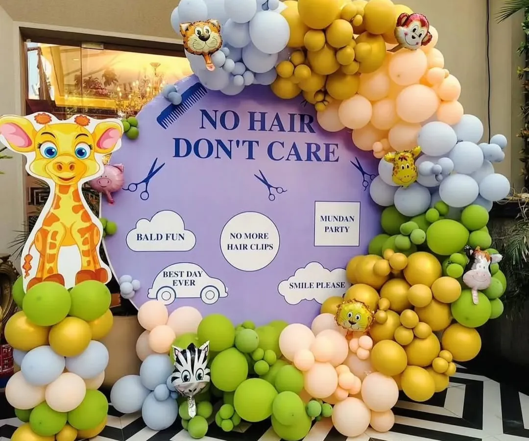 A fun and playful "No Hair Don't Care" theme for a Mundan ceremony. This setup features a custom backdrop, a vibrant pastel balloon arch, and adorable jungle animal cutouts like a giraffe and zebra.