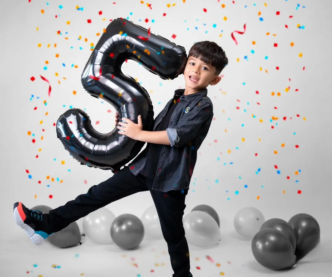 Celebrating a milestone like turning five should be full of energy and joy. I designed this studio setup with bright confetti and balloons to match his vibrant personality. My goal is to capture the pure, unscripted happiness of the moment, creating a memory as lively as the celebration itself.
