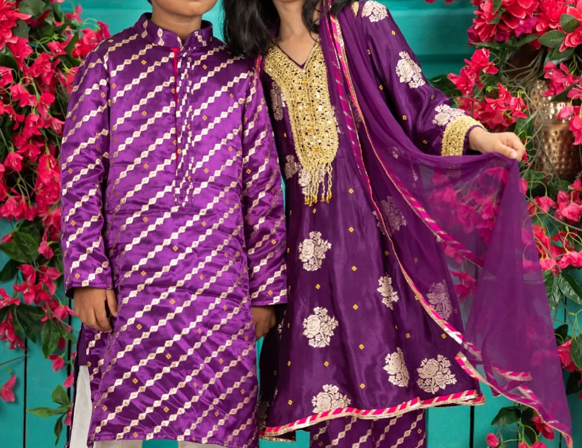 Creating coordinated outfits for brothers and sisters is one of my greatest joys. This vibrant purple set features a silk kurta with diagonal zari work for him and a matching sharara with intricate gold embroidery for her, perfect for a wedding or festive event.