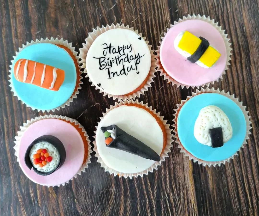 For the sushi lover, this set features a variety of hand-sculpted fondant sushi pieces, including nigiri, maki, and temaki rolls, all sitting on colorful, edible discs.