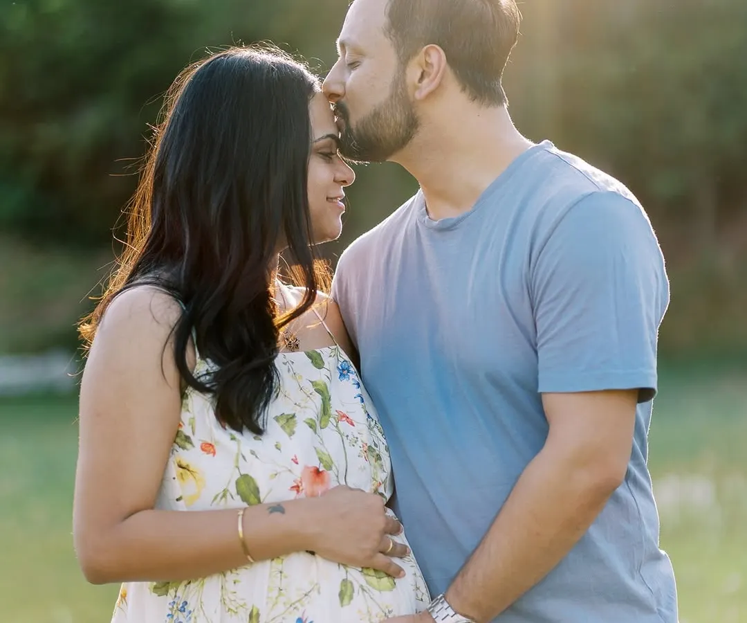 There's something magical about a sunset session. Here, the golden light wraps around this beautiful couple, highlighting the tender kiss and the promise of their growing family. Outdoor maternity photography in a natural setting like this feels so timeless.