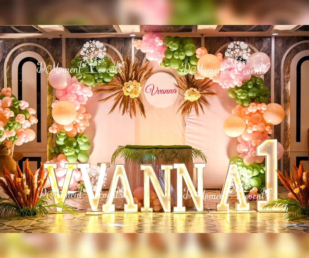 For Vivanna's first birthday, we designed a chic boho-themed stage featuring custom light-up marquee letters. The setup combines soft pastel and earthy green balloons with dried pampas grass accents to create a warm and stylish focal point for the celebration.