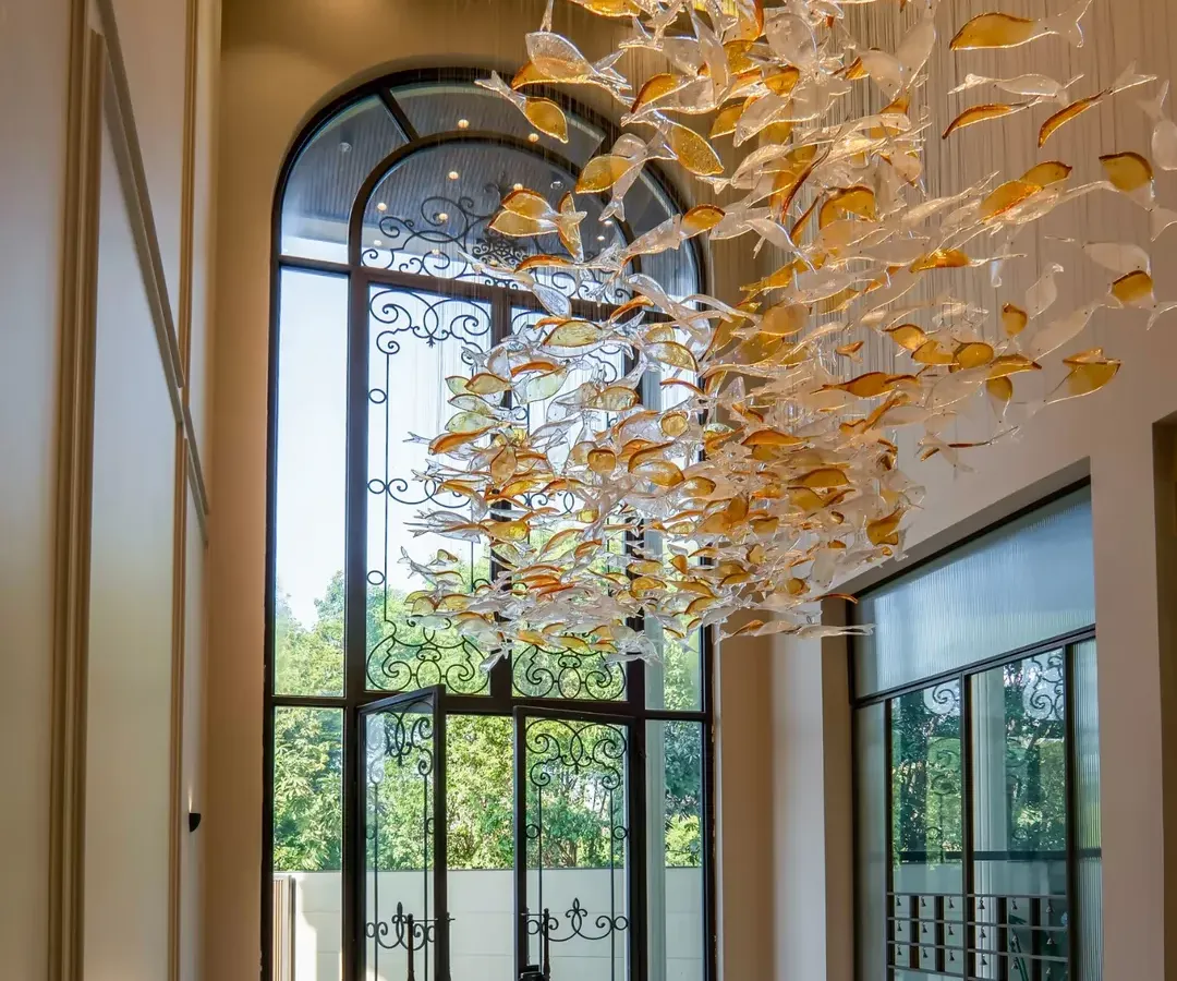 The entrance of our Sultanpur farmhouse sets a tone of neo-classical elegance. The custom-designed fish chandelier is a floating sculpture in the double-height foyer, welcoming you into a space where every detail is a piece of art.