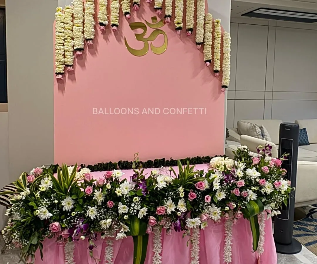 For Ganesh Chaturthi, I focus on creating a peaceful and modern space. This setup features a clean, pink arched backdrop with a golden 'Om' symbol, complemented by a cascade of fresh tuberose garlands. The base is heavily decorated with a mix of white and pink flowers, creating a serene and beautiful corner to welcome Bappa.