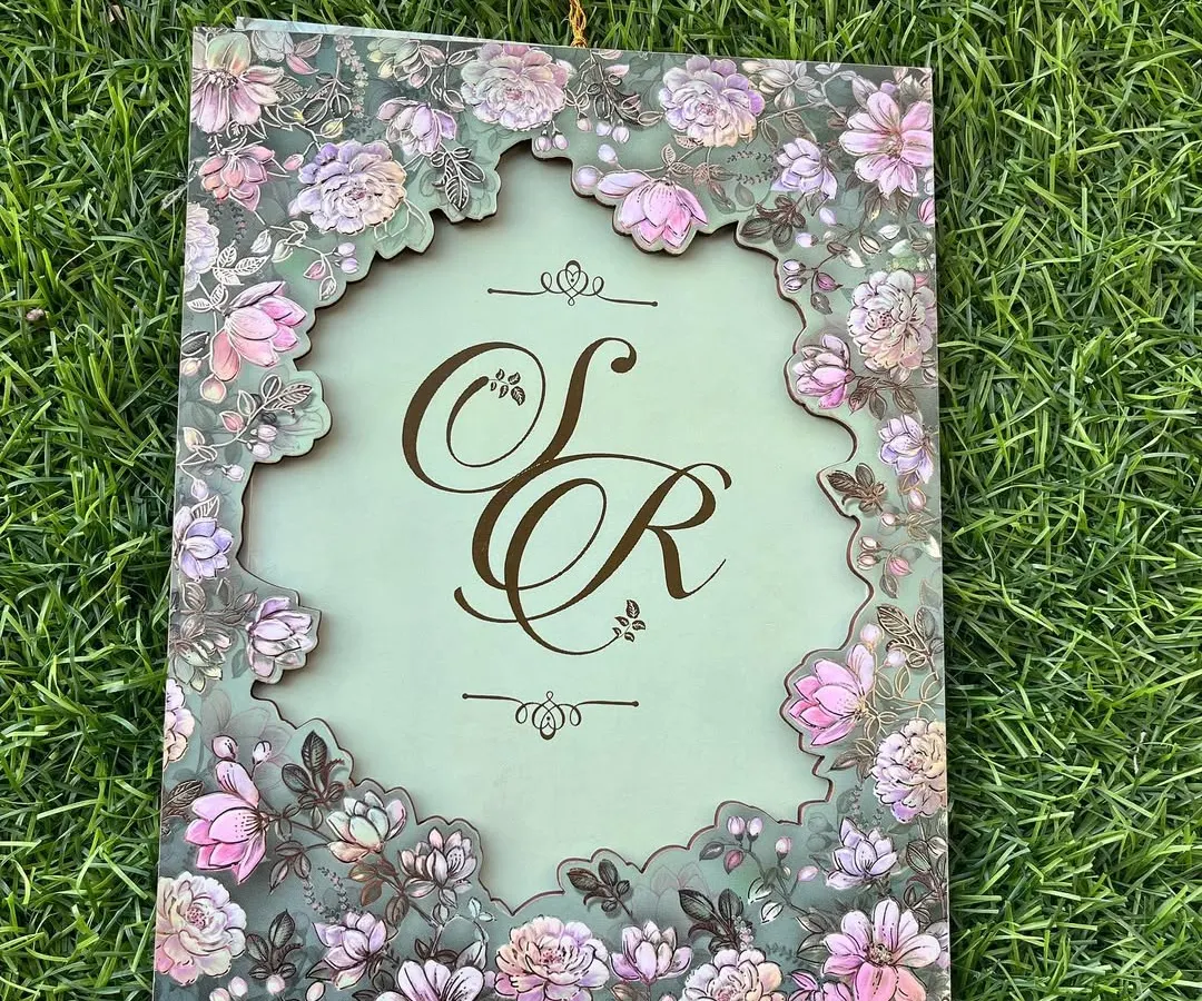 The beauty is in the details. This design features an intricate floral laser-cut frame on a soft sage green, revealing a custom monogram that tells your unique love story. It’s a piece of art that your guests will treasure.