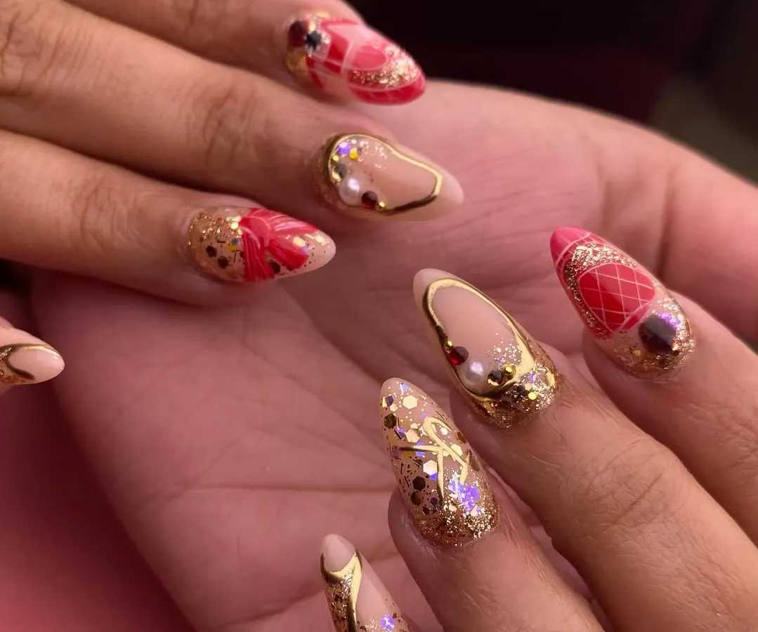 A bridal set fit for a queen. This design features a mix of intricate details on almond-shaped nails, including gold glitter, delicate pearls, 3D red bow embellishments, and a quilted pattern. It’s the ultimate in wedding day opulence.