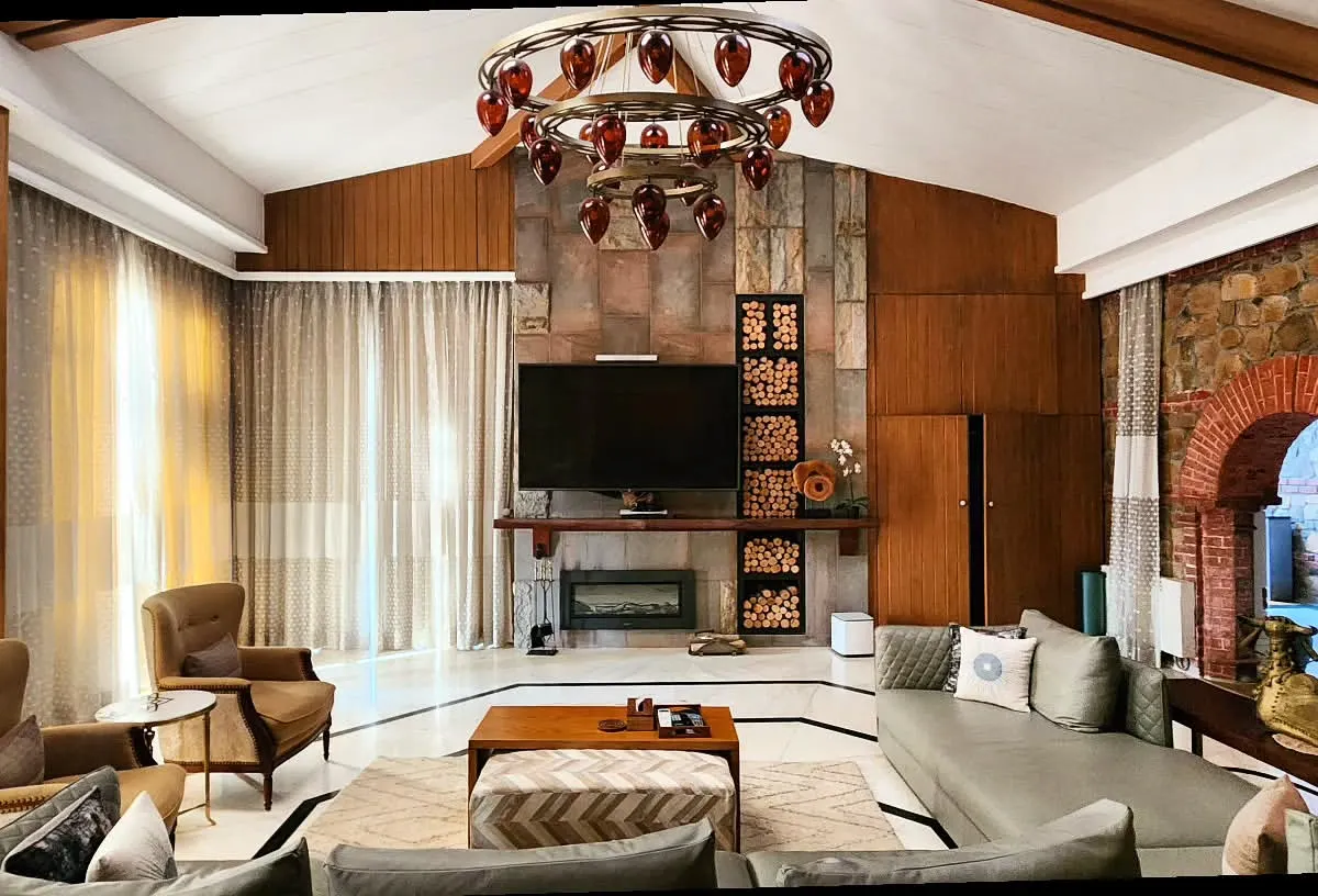 This living room is the heart of a renovated Haveli, where I blended rustic warmth with refined elegance. The exposed stone wall and wood paneling provide a tactile, earthy backdrop for modern furniture, all connected by a traditional brick archway that honors the home's heritage.