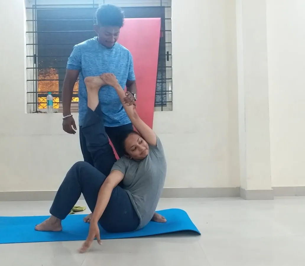 Hands-on adjustments are a key part of my teaching. Here, I am helping a student find the correct alignment in a seated twist. This personal guidance ensures you practice safely, understand the posture deeply, and get the most out of every movement.