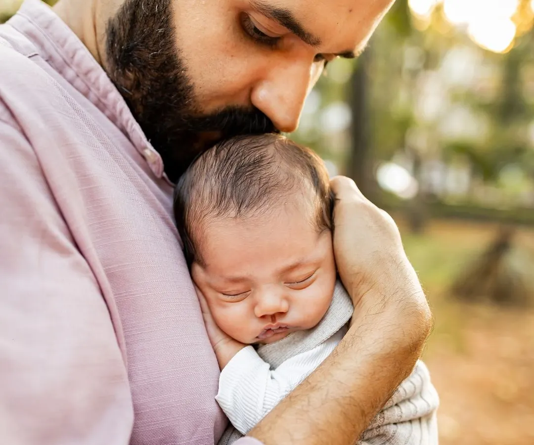 There's something magical about the golden hour light, especially when it's wrapping a new father and his baby in warmth. This tender moment, a quiet kiss on the forehead, shows the deep, instant bond that I feel so privileged to witness and photograph during my outdoor newborn sessions.