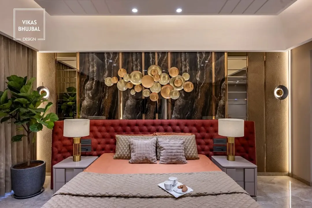 We designed this master bedroom to be a statement of bold elegance. A floor-to-ceiling upholstered headboard in rich crimson is set against a dark marble panel with a bespoke metallic art installation, creating a dramatic and luxurious focal point.