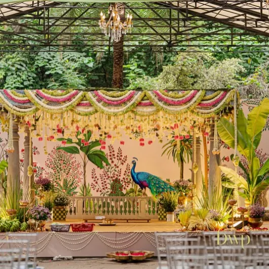 We brought a touch of royal heritage to this South Indian wedding with a custom-designed mandap. The backdrop features hand-painted Pichwai art with a majestic peacock, framed by pillars and lush floral arrangements, creating a sacred and elegant space for the ceremony.