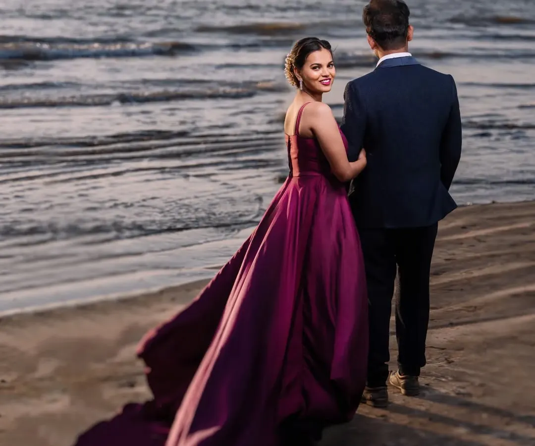 A cinematic moment at dusk. The way her gown catches the sea breeze creates a truly dramatic and romantic pre-wedding portrait. This is about making you feel like the heroes of your own love story.