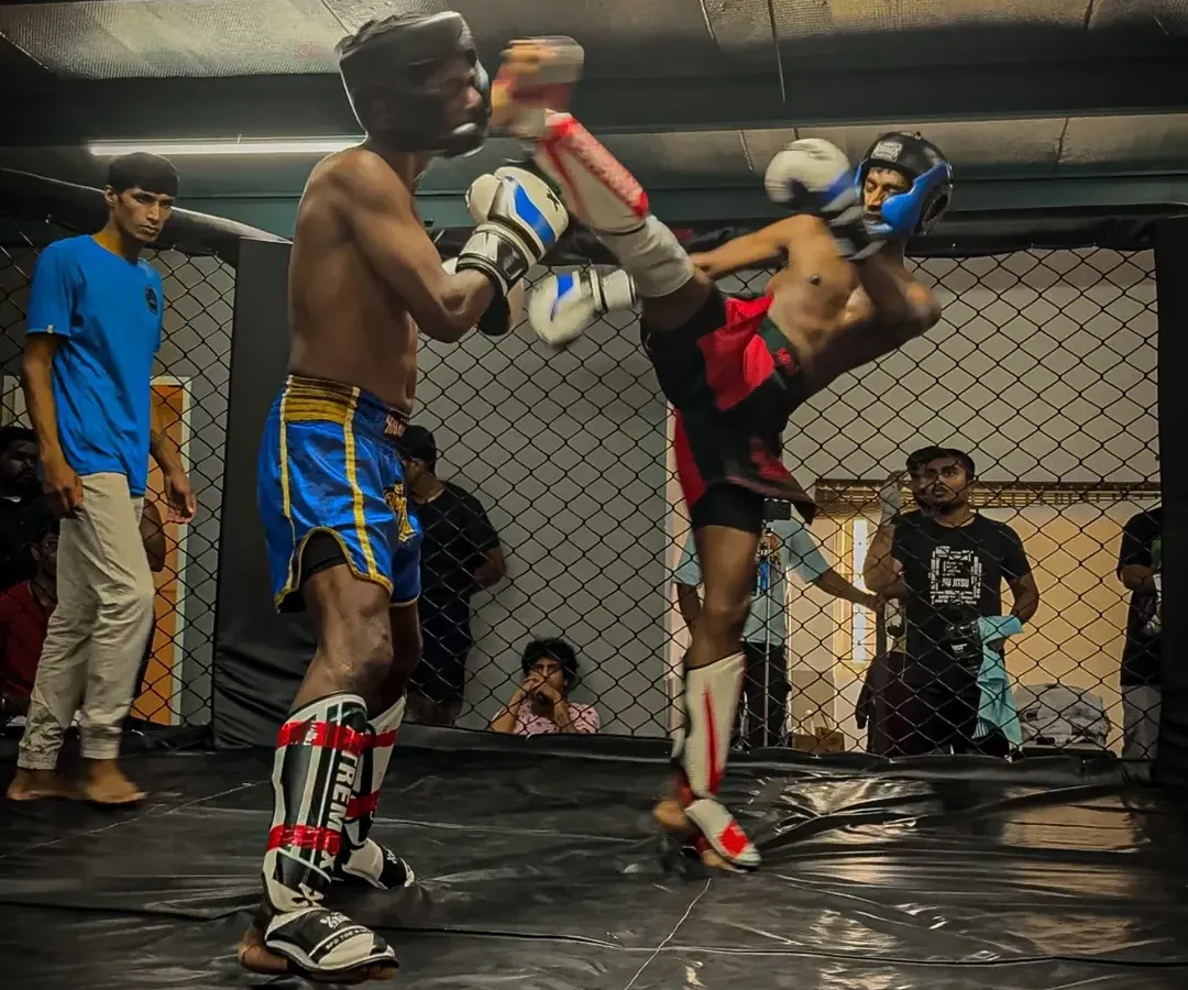 Our training is relentless because the fight demands it. Here, one of our fighters executes a powerful high kick during an in-house kickboxing tournament, a testament to the striking skills we build.