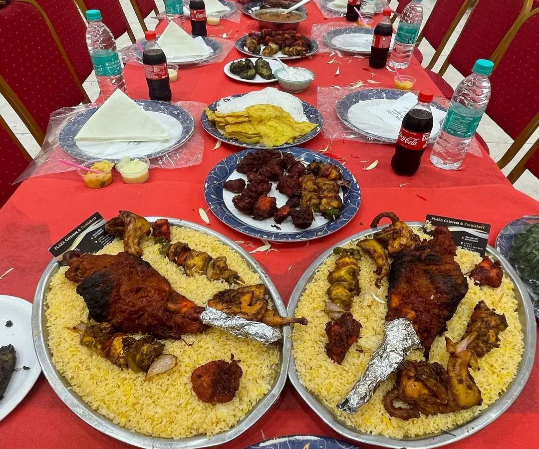 This is our specialty, the Dastarkhwan setup for a grand wedding feast. We arrange long tables with a full spread of starters, salads, and our famous Mandi-style biryani platters featuring whole roasted chicken, ready for the guests to arrive.