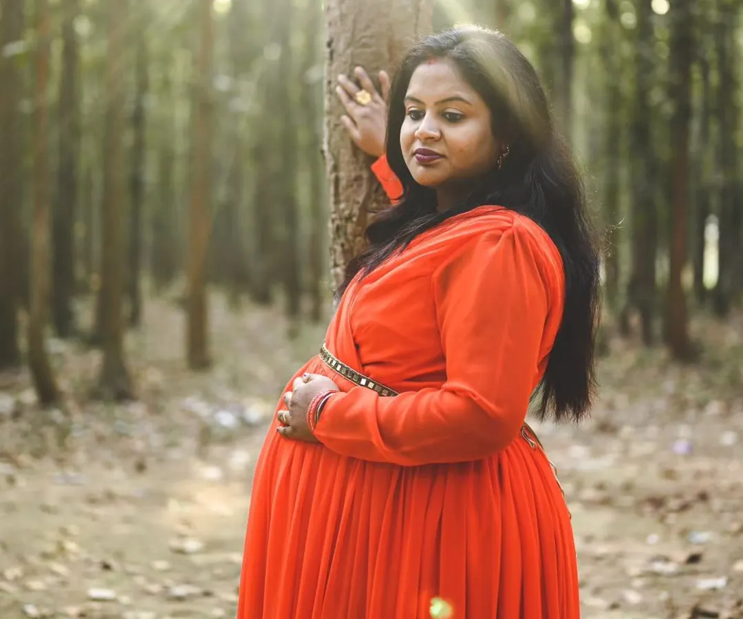 For this maternity session, we went to a beautiful forest trail to capture the perfect shot. The sunlight filtering through the trees created this stunning natural glow on the mother-to-be in her vibrant red dress, making for a truly magical portrait.