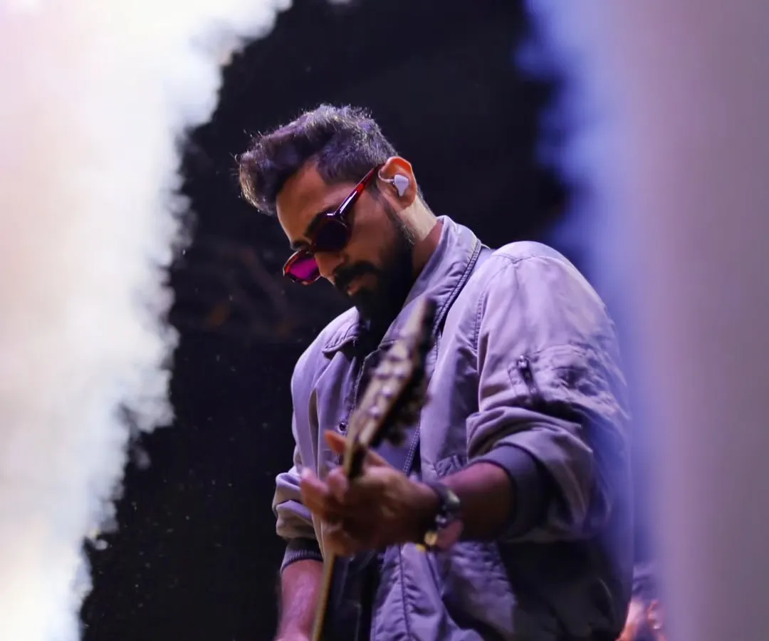 I work with the elements of the stage, using smoke and dramatic lighting to frame the musician. This shot captures the atmosphere of a live show, where the music itself feels visible.