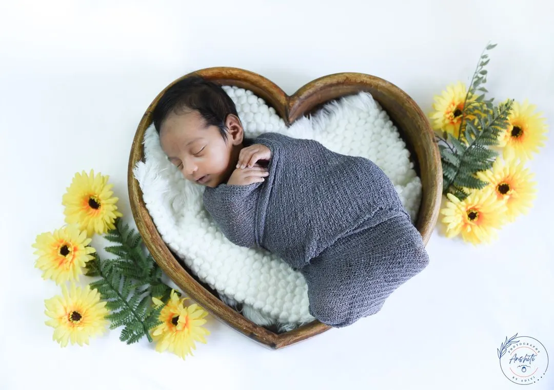 So tiny and perfect. In our newborn sessions, we create a safe and cozy space, using soft props like this heart-shaped bowl to photograph your baby's earliest, most peaceful moments.
