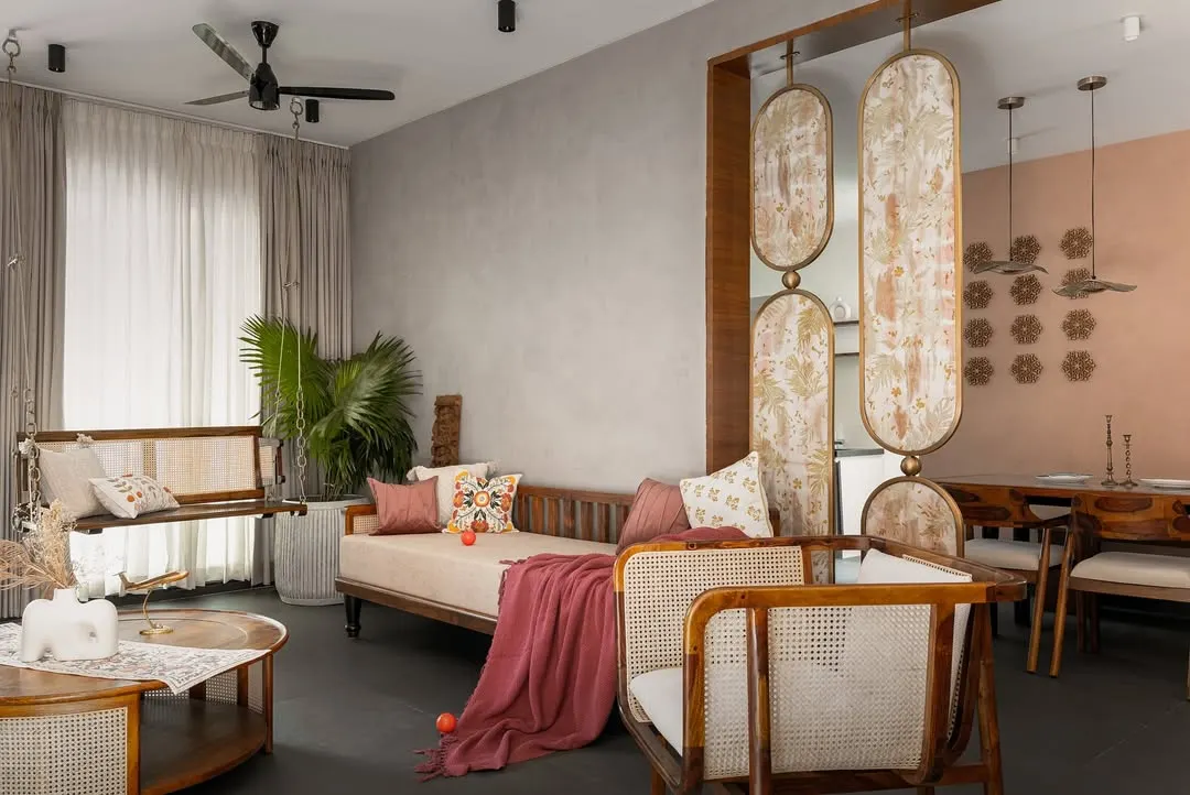 The living space in the 'Ittige' residence combines traditional Indian elements like a wooden swing with contemporary furniture. We used a mix of textures, from the concrete-finish walls to cane chairs and soft textiles, to create a warm and inviting family area that feels both modern and timeless.