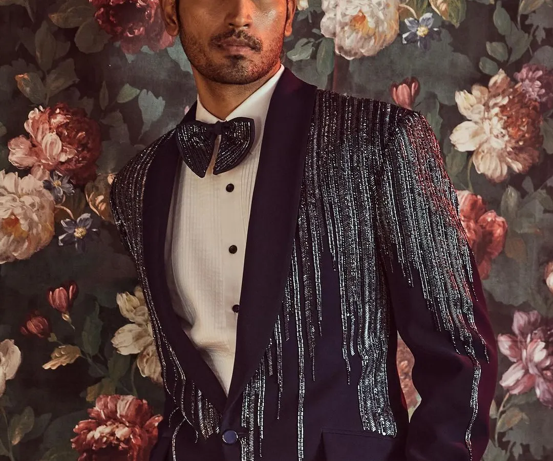 We redefine formal wear with this modern tuxedo, featuring a shawl lapel embellished with a cascade of kut-dana work for a touch of sophisticated glamour.