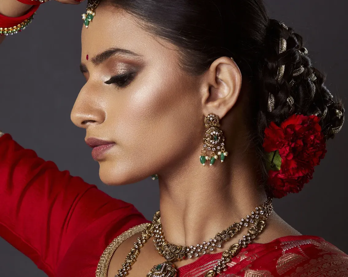 A closer look at my signature bridal style. I created a sharp, smokey eye and paired it with a flawless, glowing base. The traditional bridal bun is adorned with fresh red carnations for a classic royal touch.