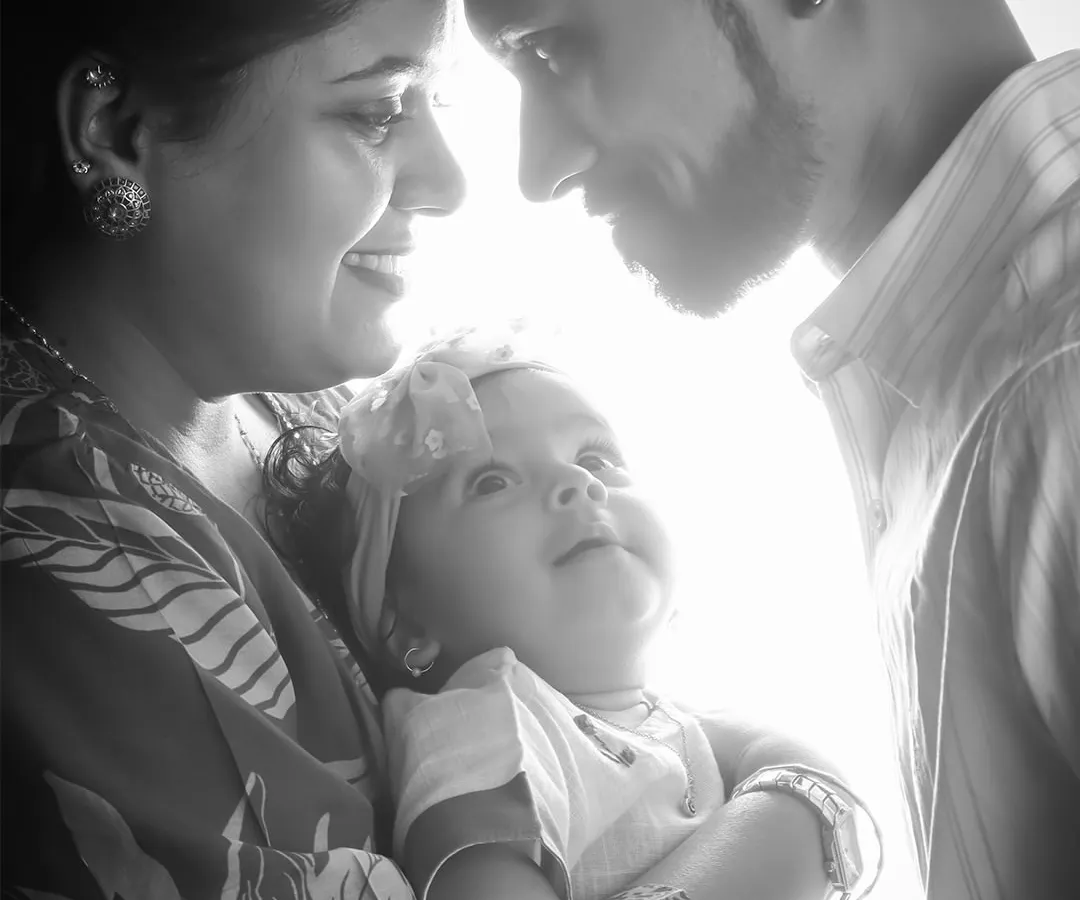 I love using light and shadow to create artistic and emotional portraits. This black and white image captures an intimate, quiet moment between new parents and their baby, focusing on their bond without any distractions.