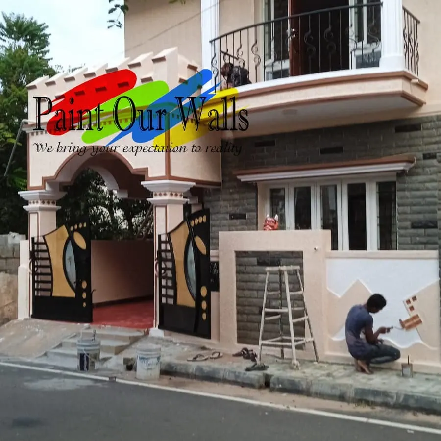 My process is thorough and careful. You can see one of my professional painters meticulously working on the compound wall, ensuring a clean and perfect finish while protecting the surrounding areas.