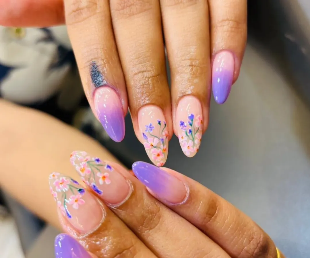 We combined two trends in one with this beautiful set. It features a soft lavender-to-nude ombre base on almond-shaped extensions, with delicate, hand-painted floral art on select nails for a touch of whimsical elegance.