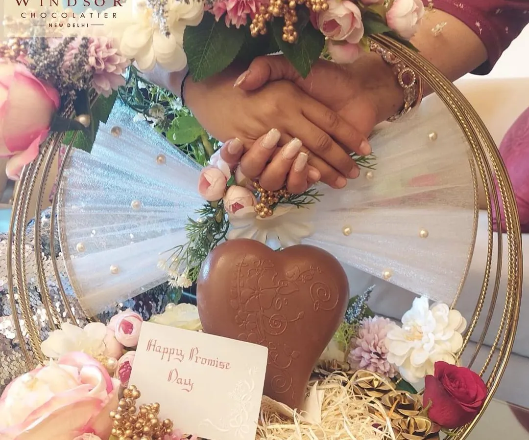 We love creating unforgettable gifts for your special moments. This custom hamper was designed for a Promise Day celebration, featuring a large chocolate heart, assorted confections, and beautiful floral arrangements.