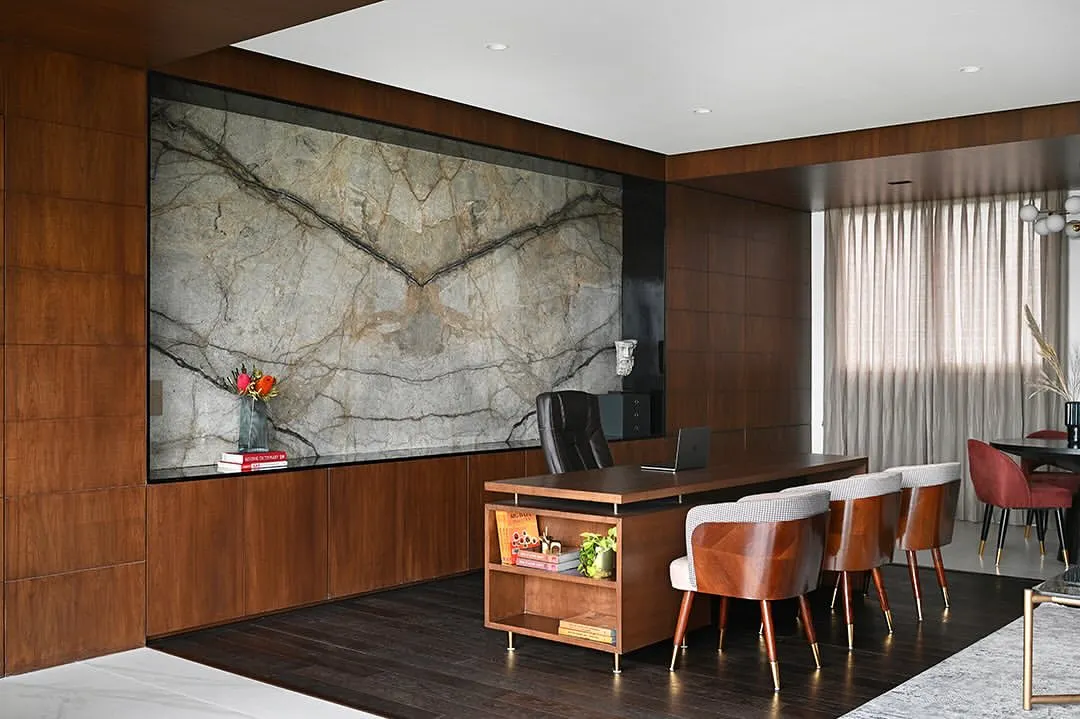 For this Chairman's office, we aimed for quiet luxury. The centerpiece is a book-matched marble slab that acts as a piece of art, complemented by rich wood paneling and a bespoke desk, creating a space that is both powerful and serene.