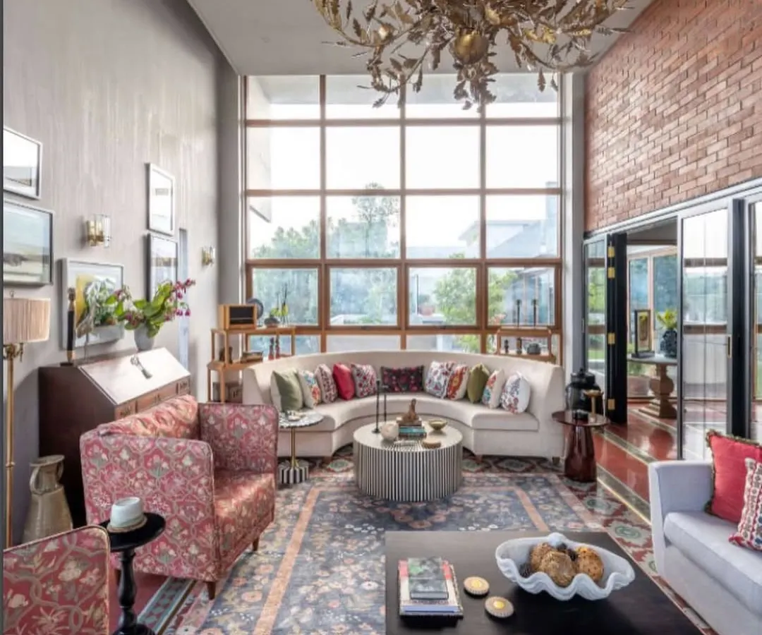For a contemporary home in Dhaka, we created a space that felt both grand and intimate. The double-height windows flood the room with light, illuminating the blend of modern furniture and traditional textures, like the exposed brick wall and handwoven rug. It’s a space designed for conversations, where the old world and the new can meet.
