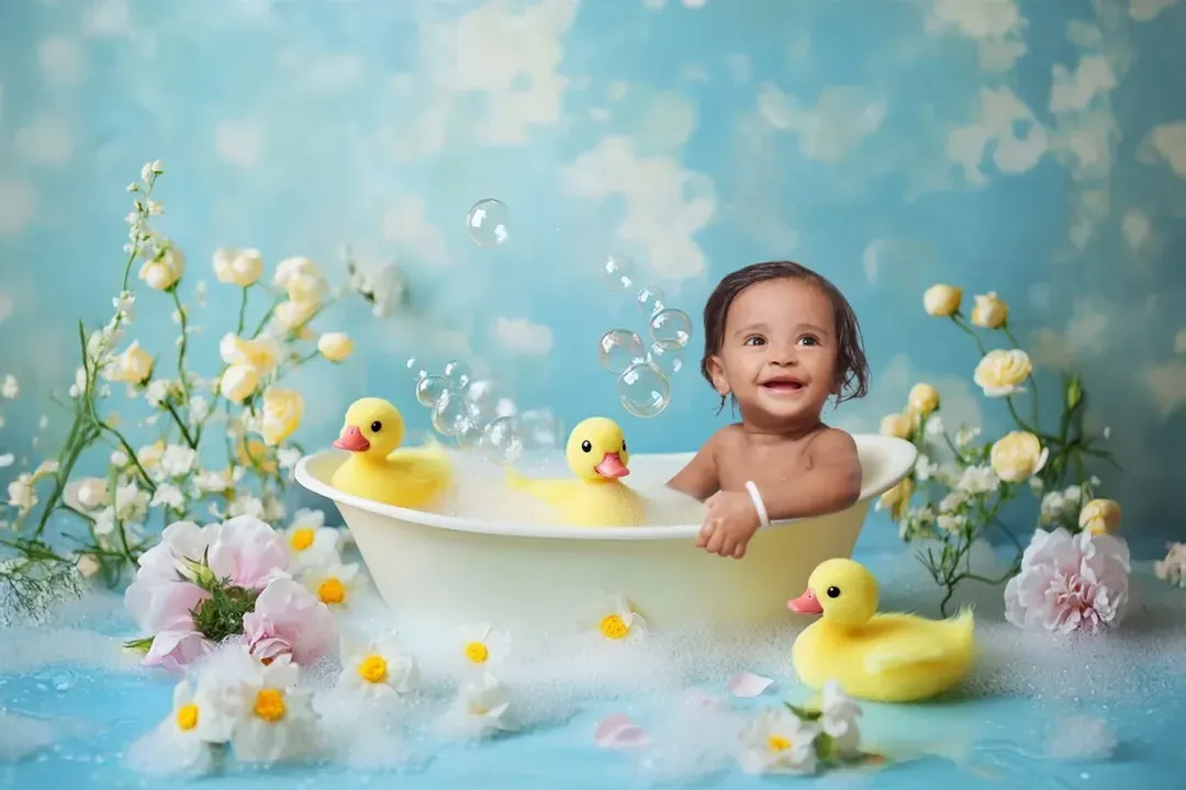 Pure joy in a tub. This is an example of a fun and creative baby photoshoot, complete with bubbles, rubber ducks, and a beautiful floral setup. I ensure your baby is comfortable and happy throughout these playful sessions.