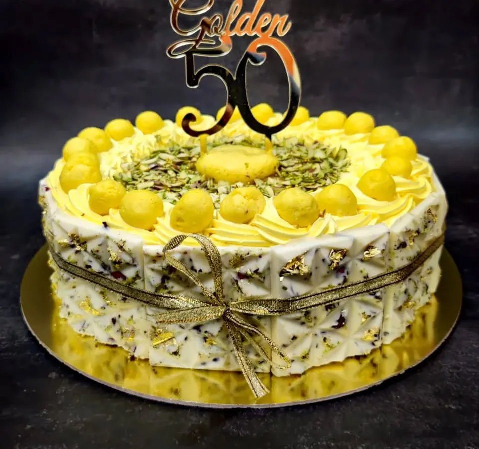 My Royal Rasmalai Cake is one of my bestsellers, perfect for celebrating major milestones like a 50th birthday. I infuse the light sponge with traditional rasmalai flavor and top it with actual rasmalai pieces, pistachios, and delicate gold leaf for a truly luxurious Indian fusion dessert.