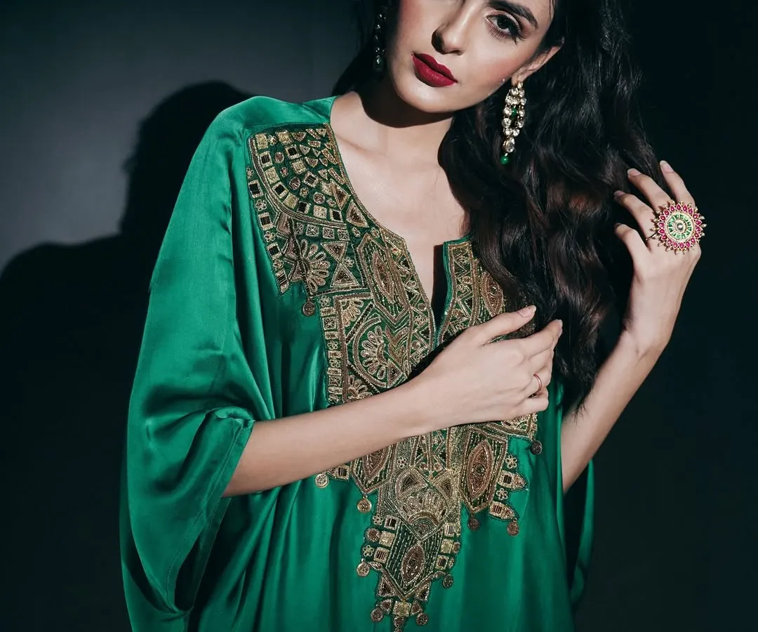 In this studio portrait, I used dramatic, low-key lighting to emphasize the luxurious feel of the emerald green kaftan. The focus is on the intricate gold embroidery and the model's commanding presence, creating a powerful image for a designer campaign.