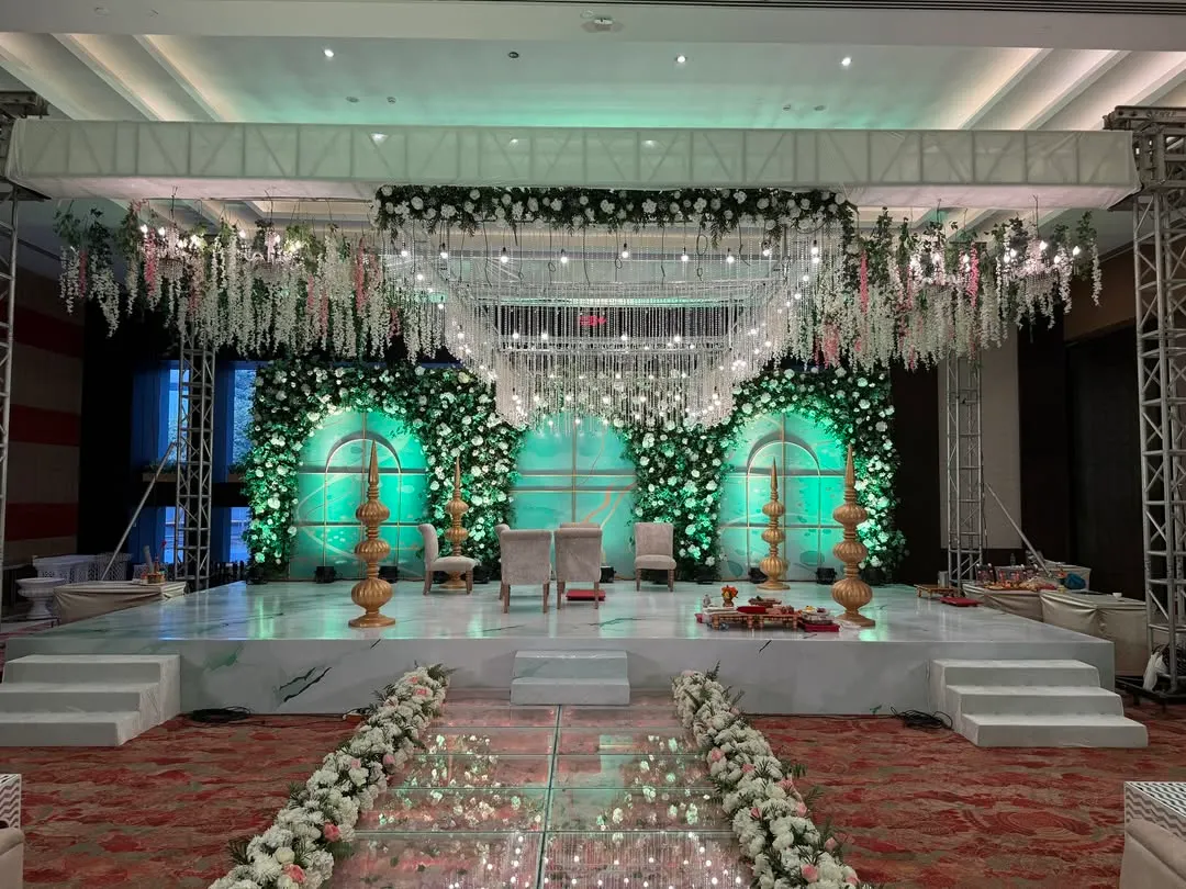 This is where fairytales come to life. I designed this ethereal mandap with a reflective glass aisle and a canopy of cascading white florals, creating a magical path for the couple to walk towards their forever.