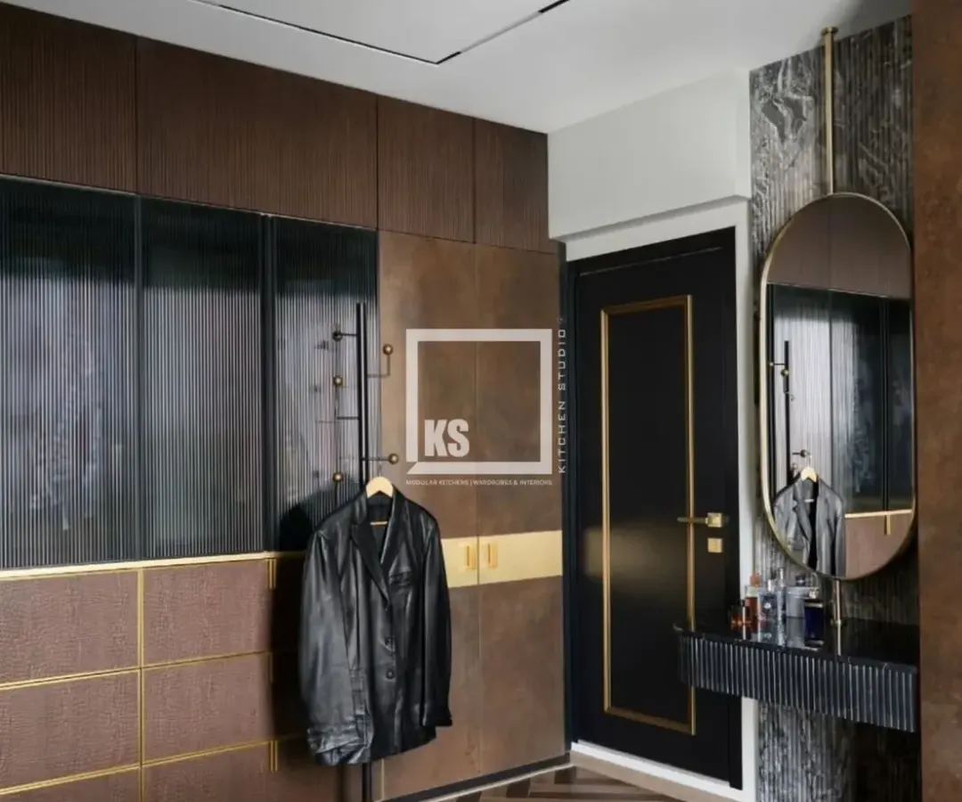 We created this moody and luxurious walk-in wardrobe using a combination of dark wood textures, ribbed glass, and brushed gold accents. The design includes a dedicated vanity area and smart storage, showing how we balance bold aesthetics with practical function.