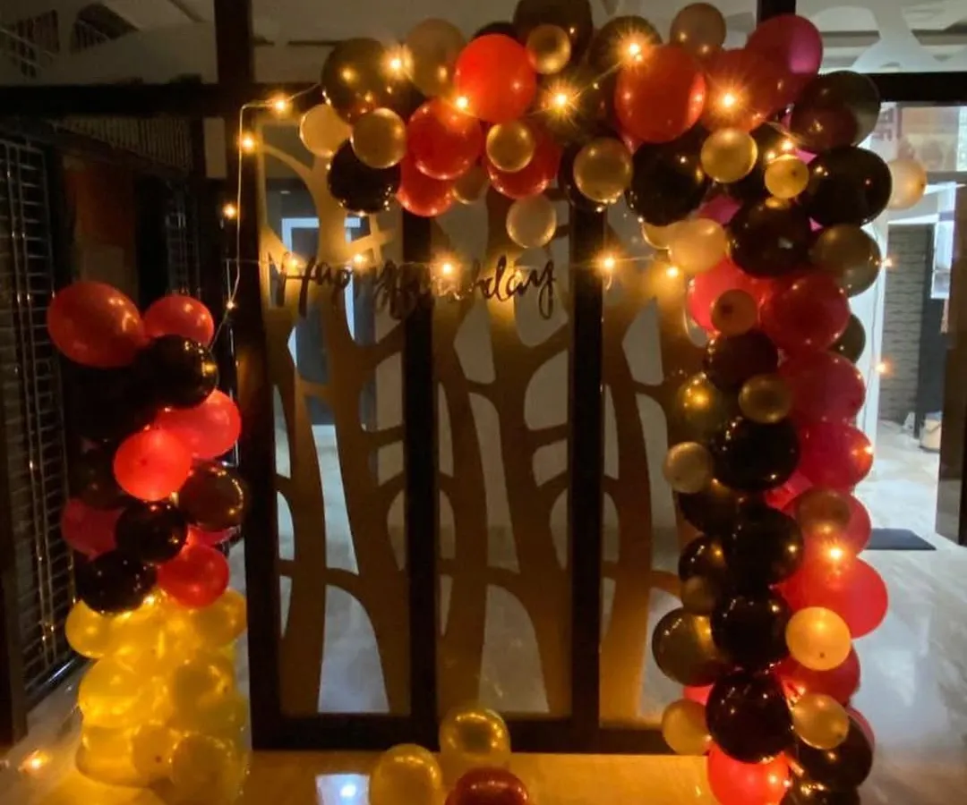This birthday party decoration combines bold red, black, and gold balloons to create a dramatic and festive arch. I added fairy lights to the arrangement to give it a warm glow, making the celebration feel extra special after dark.