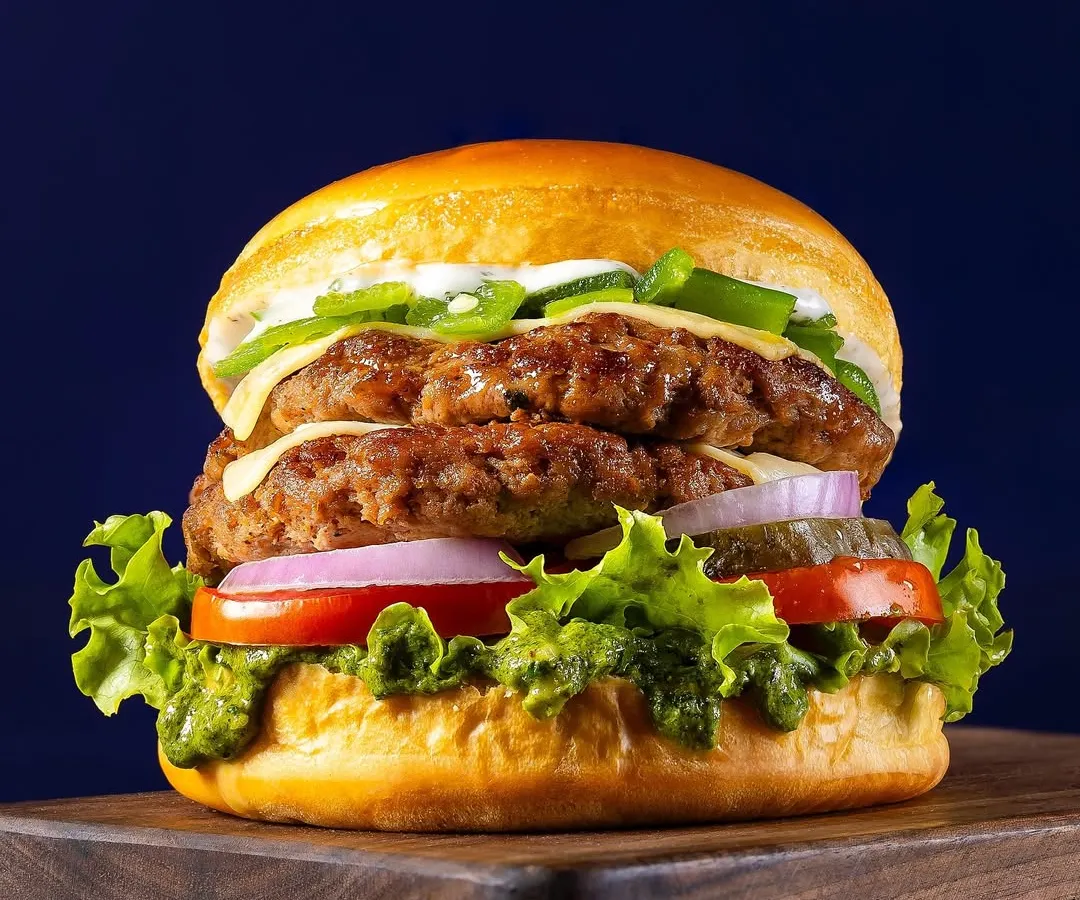 A classic double-patty smash burger, captured for Chili's 'Smasher Burgers' campaign. The focus is on creating a visually appealing, mouth-watering image that performs well for advertising and online menus, highlighting the texture of the patties and freshness of the ingredients.