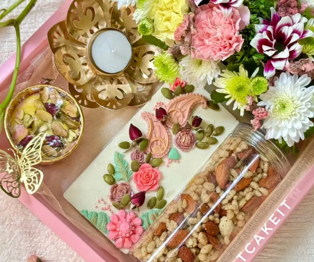 My artisanal gift hampers are perfect for any festival or special occasion. This 'Festive Bloom' Diwali hamper combines hand-painted white chocolate, a savory crunch mix, and fresh flowers for a truly elegant gift.