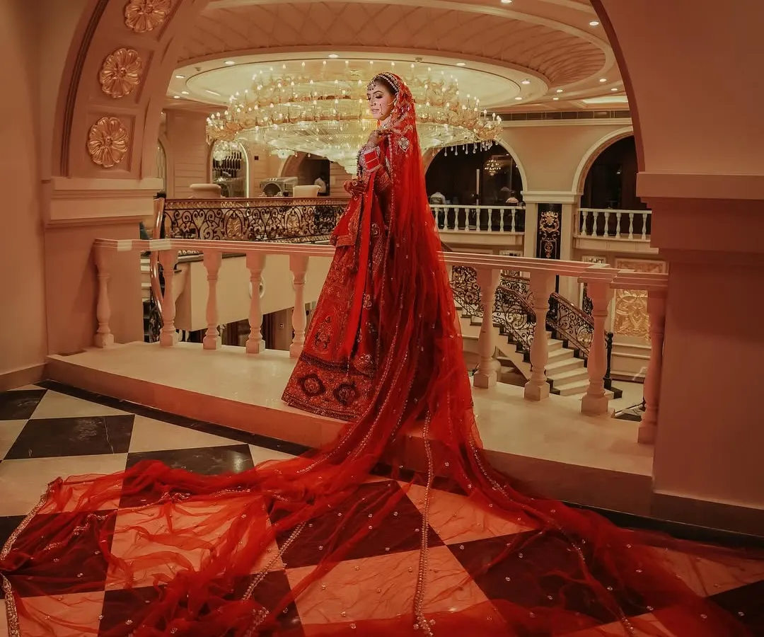 We believe a bride's entrance is a moment of pure magic. This shot captures the grandeur of a bridal lehenga with a dramatic, flowing veil, creating an iconic image that feels like a scene from a fairytale. It showcases our ability to frame monumental moments with an artistic eye.