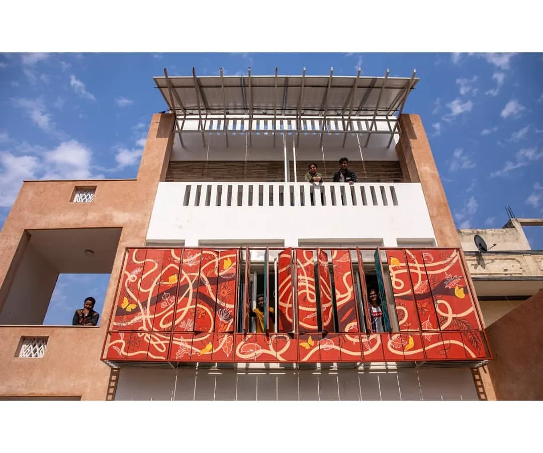 This is the facade of the Butterflies Resilience Centre in Delhi, a temporary home for street children. The vibrant, hand-painted panels are not just for beauty; they are rotating louvers that control sunlight, keeping the interiors cool. This project blends art, function, and sustainable design to create a joyful space.