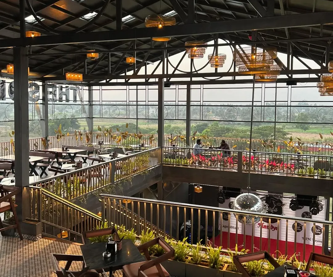 For 'The Soda Factory' pub in Mandya, we designed a multi-level green experience. This view shows how we integrated planters and greenery throughout the industrial-style space, enhancing the ambiance and offering patrons a view of the surrounding landscape.