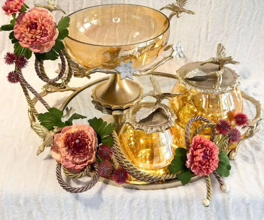 Luxury is found in the details. I have designed this amber glass and brass collection to bring a regal warmth to your home. Each piece, from the floral-adorned tray to the lidded jars, is crafted to be a timeless centerpiece for your celebrations.