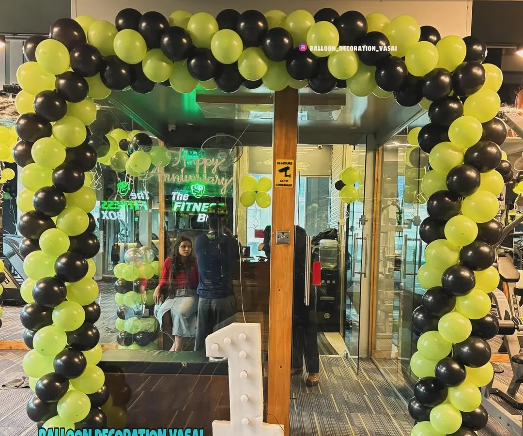 This is a full entrance balloon arch I designed for a gym's first anniversary. The energetic lime green and black color scheme matches the brand, and the large light-up number '1' makes the milestone clear from a distance.