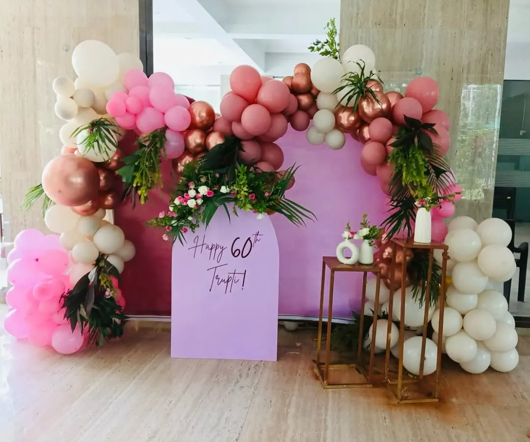 Celebrating a 60th birthday calls for elegance. For this event, I designed a sophisticated photo booth with a soft lilac arch panel, framed by a lush balloon garland in shades of dusty rose, pink, and white, accented with fresh greenery for a touch of natural beauty.