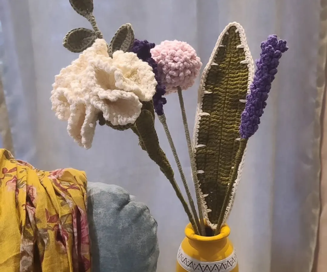 Here is one of my handmade crochet flower bouquets, perfect for adding a pop of color to your home without ever needing to water them. This arrangement features a white carnation, a pink pom-pom flower, and purple lavender, all crafted by hand and ready to brighten your space.