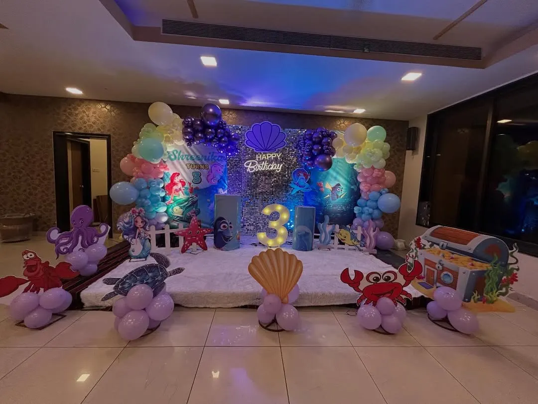 Dive into an underwater adventure! This enchanting Mermaid theme was for a 3rd birthday in Chembur. I used a shimmering sequin backdrop, character cutouts of Ariel and her friends, a light-up number '3', and balloon sculptures of crabs and octopuses to bring the ocean magic to life.
