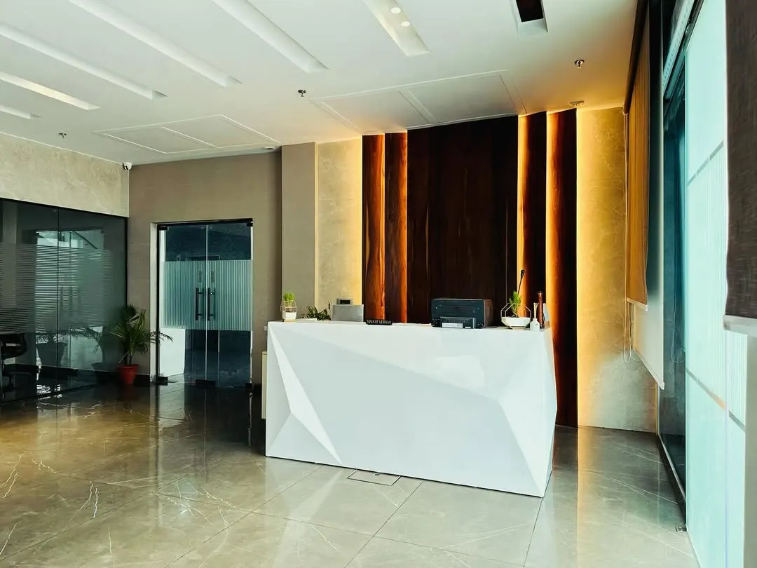 The reception area for M/s ALP in Ambala makes a powerful first impression. The design features a striking geometric desk, dramatic back-lighting on a wooden feature wall, and a polished marble floor, creating a modern and professional welcome for all visitors.