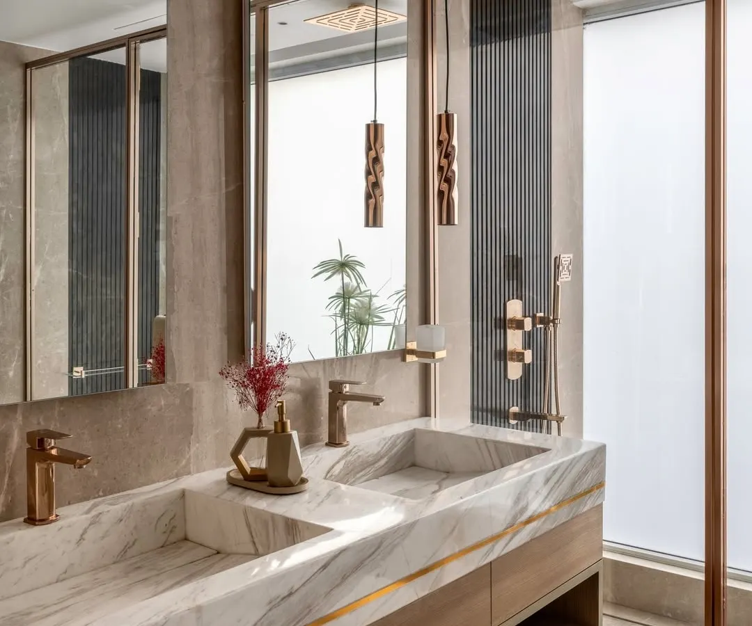 We believe bathrooms should be private sanctuaries. Here, we used exquisite white marble for the integrated double sink, paired with warm wood cabinetry and rose gold fixtures. Details like the backlit mirror and frosted glass shower partition create a spa-like atmosphere that is both functional and serene.
